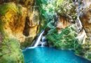 Bassin Bleu à Jacmel, Haïti, avec sa cascade et ses eaux turquoises entourées de verdure.