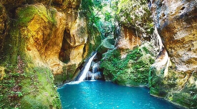 Bassin Bleu à Jacmel, Haïti, avec sa cascade et ses eaux turquoises entourées de verdure.