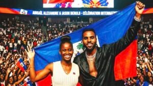 Jason Derulo et Abigaelle Alexandre brandissant fièrement le drapeau haïtien devant une foule immense lors d'un événement international.