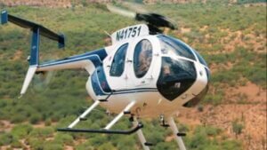 Hélicoptère léger de type MD 500E en phase d'atterrissage sur le tarmac lors du déploiement des forces spéciales en Haïti